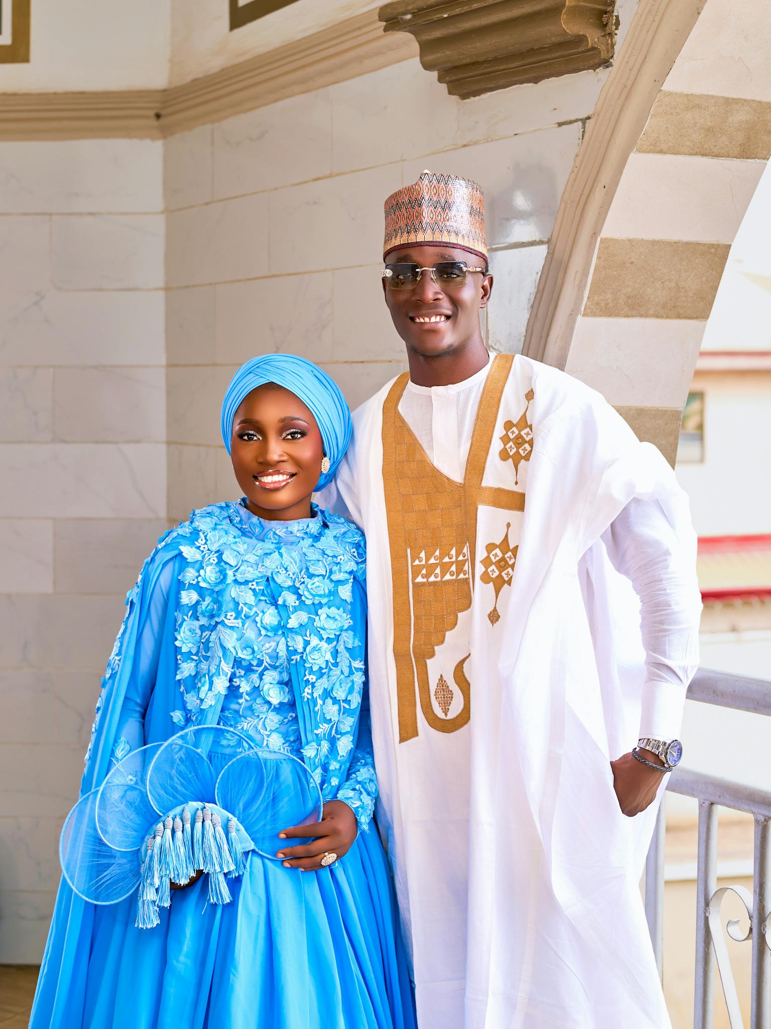 A joyful couple wearing traditional Nigerian clothing, captured posing indoors.