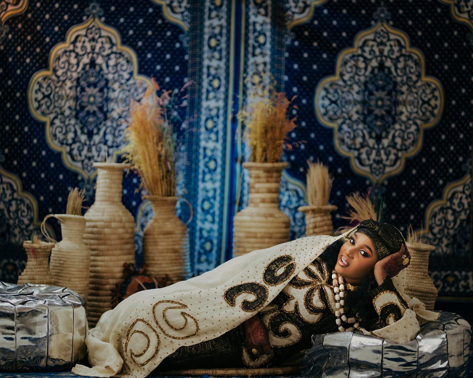 Beautifully adorned bride in traditional Nigerian garment, displaying cultural elegance and decor.