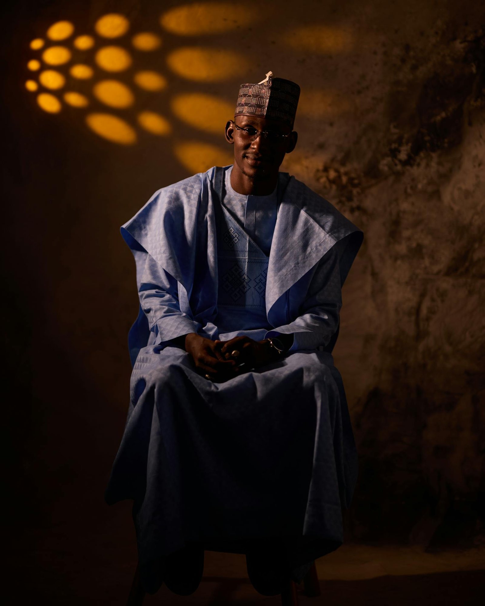 Captivating portrait of a man wearing traditional Nigerian clothing, set against a textured background.